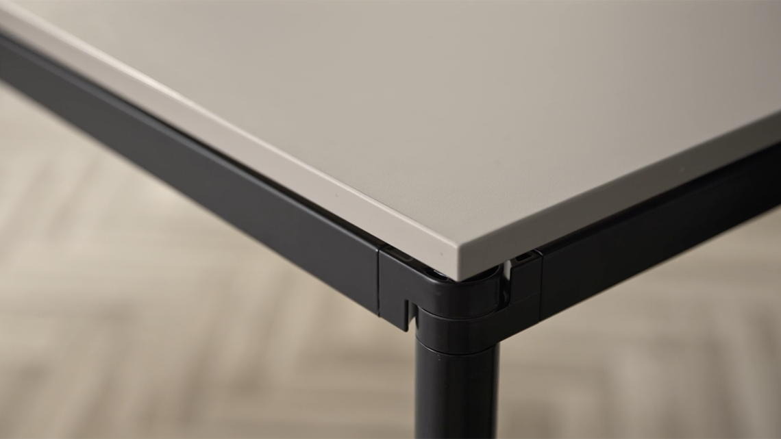 A detailed image of a Simpla table with a black frame and brownish tabletop 
