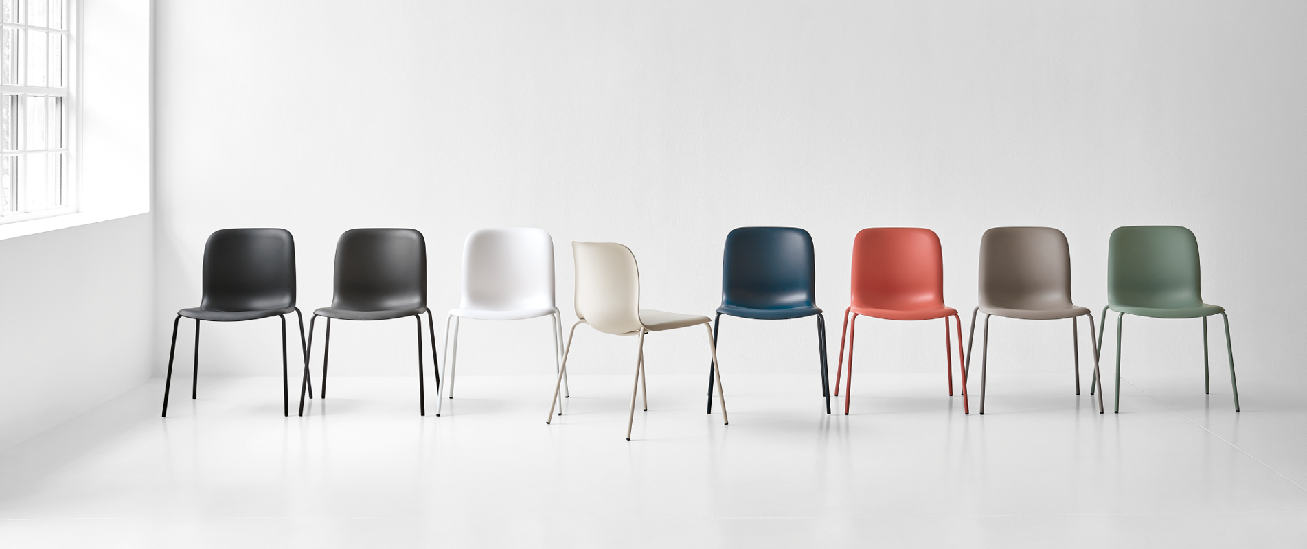 An installation image of the Sixe family in the Colours of Denmark; 4-leg in a row; Howe grey, Chalk, Wheat, Ocean, Red ochre, fawn and Lichen polypropylene shells