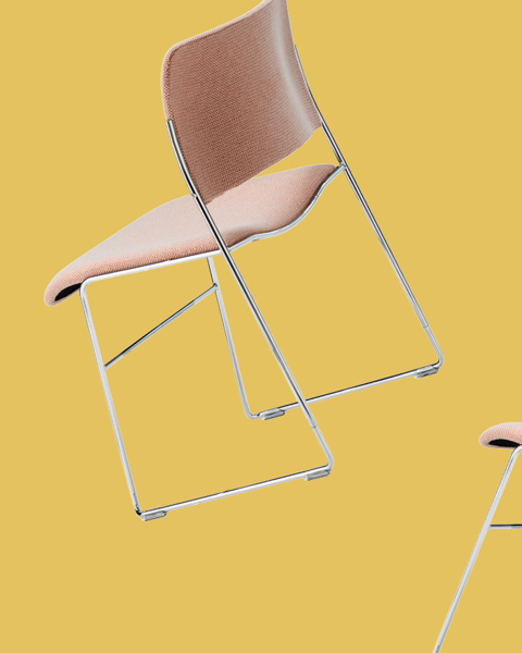 Pink-upholstered 40/4 chair against a yellow background