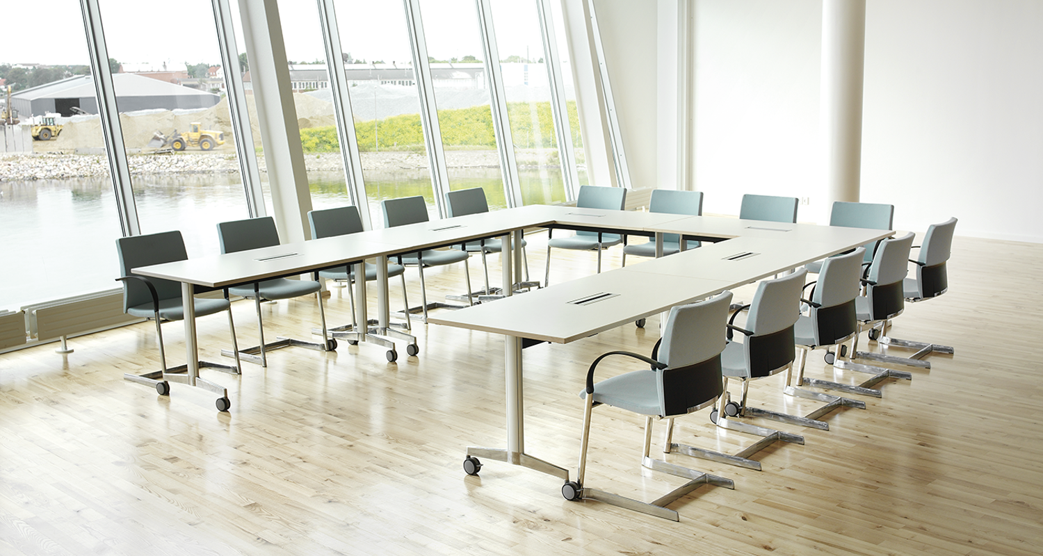 A "U" shape installation with Moveo tables in a conference room with big windows