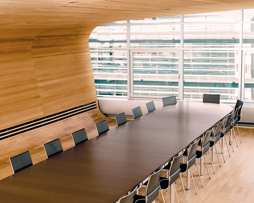 A long Simpla table and black chairs in a conference room